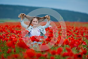 Beauty blue eyes teen enjoy summer days .Cute fancy dressed girl in poppy field. Field of blooming poppies