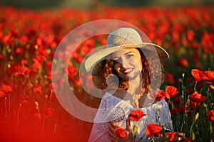 Beauty blue eyes teen enjoy summer days .Cute fancy dressed girl in poppy field. Field of blooming poppies.