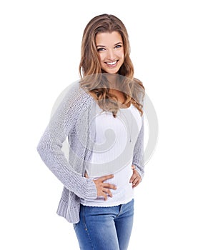 Beauty in blue jeans. A young woman in casual wear standing against a white background and smiling at the camera.