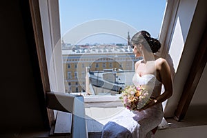 Beauty bride in bridal gown with bouquet and lace veil indoors