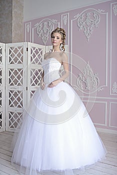 Beauty bride in bridal gown indoors