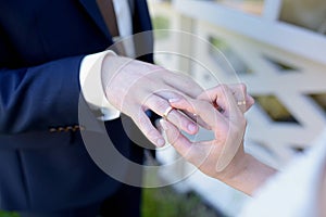 Beauty bride and handsome groom are wearing rings each other