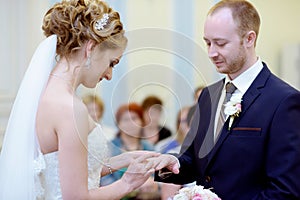 Beauty bride and handsome groom are wearing rings each other