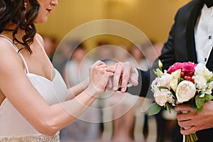 Beauty bride and handsome groom are wearing rings each other