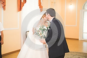 Beauty bride and handsome groom are wearing rings each other. Wedding couple on the marriage ceremony.