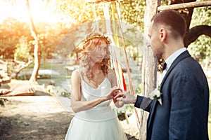 Beauty bride and handsome groom are wearing rings each other. Wedding couple on the marriage ceremony. Beautiful model girl in whi