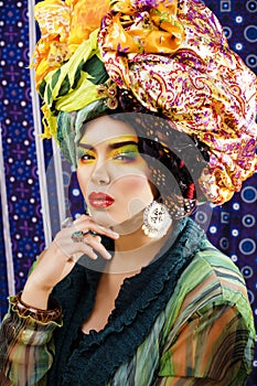 Beauty bright woman with creative make up, many shawls on head like cubian, ethno look closeup