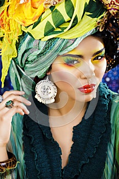 Beauty bright woman with creative make up, many shawls on head like cubian, ethno look closeup