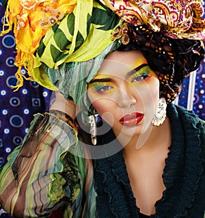 Beauty bright woman with creative make up, many shawls on head like cubian, ethno look closeup