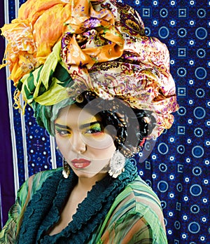 Beauty bright woman with creative make up, many shawls on head like cubian, ethno look closeup