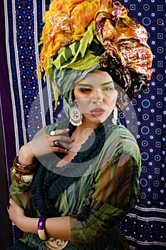 Beauty bright woman with creative make up, many shawls on head like cubian, ethno look closeup