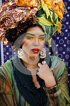 Beauty bright woman with creative make up, many shawls on head like cubian, ethno look closeup