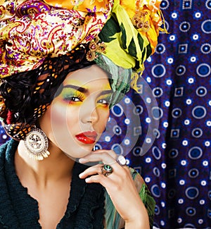 beauty bright woman with creative make up, many shawls on head like cubian, ethno look closeup