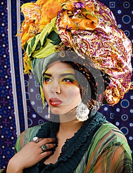 beauty bright woman with creative make up, many shawls on head like cubian, ethno look closeup