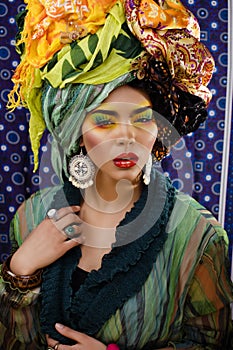 beauty bright woman with creative make up, many shawls on head like cubian, ethno look closeup