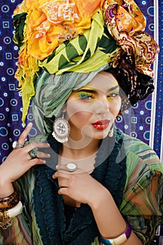 beauty bright woman with creative make up, many shawls on head like cubian, ethno look closeup