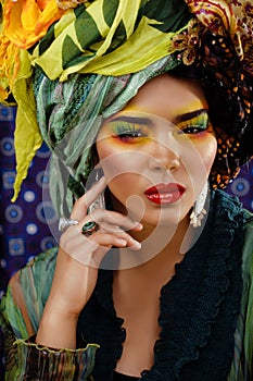 beauty bright woman with creative make up, many shawls on head like cubian, ethno look closeup