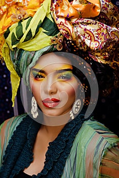 Beauty bright woman with creative make up, many shawls on head like cubian, ethno look closeup