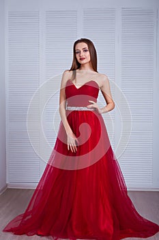 Beauty brunette model woman in evening red dress. Beautiful fashion luxury makeup and hairstyle. Seductive girl