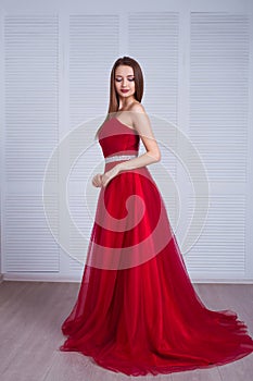 Beauty brunette model woman in red evening dress. Beautiful fashion luxury makeup and hairstyle. Seductive girl
