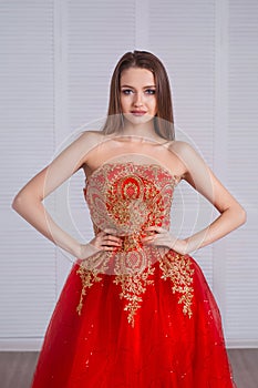 Beauty brunette model woman in red evening dress. Beautiful fashion luxury makeup and hairstyle. Seductive girl