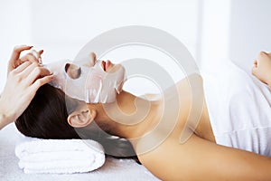 Beauty and Care. Beautiful Young Girl in Spa Salon. Facial Procedures. Face Mask. Girl with Pure and Beautiful Skin