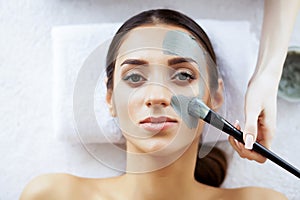 Beauty and Care. Beautiful Young Girl in Spa Salon. Facial Procedures. Face Mask. Girl with Pure and Beautiful Skin