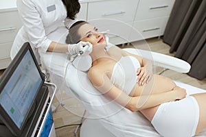 Beauty Clinic. Pregnant Woman Doing Intense Peeling Treatment