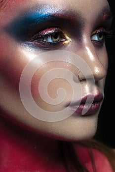 Beauty close-up portrait of beautiful woman model face with magic creative fashion multicolored make-up. Face painting, cosmetics,