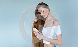 Beauty close-up portrait of beautiful young woman with long brown hair on white background. Hair care concept.