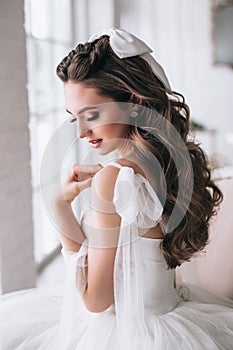 Beauty close-up portrait of bride with luxury make-up and hairstyle looking down