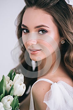 Beauty close-up portrait of young bride with luxury make-up and hairstyle in studio.