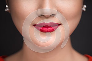 Beauty. Close up view of beautiful woman lips with red matt lips