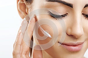 Beauty Closeup happy young woman apply cream to her face Skincare and cosmetics concept. Cosmetics. Woman face skin care.Natural