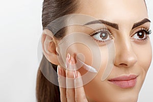 Beauty Closeup happy young woman apply cream to her face Skincare and cosmetics concept. Cosmetics. Woman face skin care.Natural