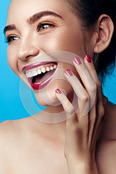 Beauty closeup portrait of white young smiling girl in pastel blue caramel and pink tones makeup. Vertical photo