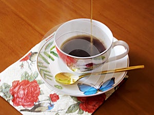 Beauty coffeecup standing on wooden table with dark tasty coffee