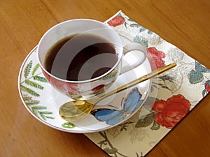 Beauty coffeecup standing on wooden table with dark tasty coffee