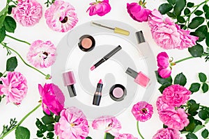 Beauty composition with pink flowers bouquet and make up cosmetics on white background. Top view. Flat lay feminine desk.