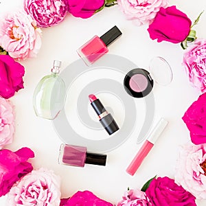 Beauty composition with pink flowers and make up cosmetics with aroma on white background. Top view. Flat lay feminine desk
