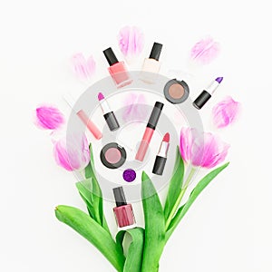 Beauty composition with pink tulips bouquet and cosmetics on white background. Top view. Flat lay home feminine desk.