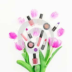 Beauty composition with pink tulips bouquet and cosmetics on white background. Top view. Flat lay. Home feminine desk.