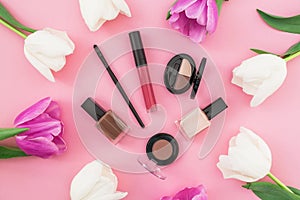 Beauty composition with tulips flowers and cosmetics on pink background. Top view. Flat lay. Home feminine desk.