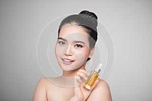 Beauty concept. Asian pretty woman with perfect skin holding oil
