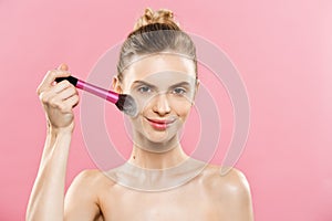 Beauty Concept - Closeup Beautiful caucasian woman applying makeup with Cosmetic Powder Brush. Perfect Skin. Isolated on