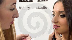 Beauty concept. Makeup artist doing face make up to young woman