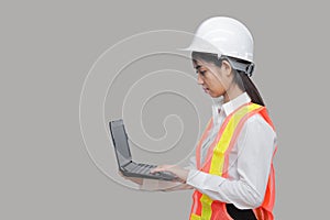 Beauty confident young Asian worker with safty equipment carrying laptop on gray isolated background photo