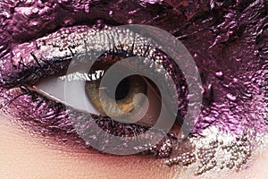 Beauty, cosmetics and makeup. Magic eyes look with bright creative make up. Macro shot of beautiful woman