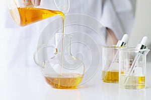 Beauty cosmetics sciences, Formulating and mixing skincare with herbal essence, Scientist pouring organic essential oil