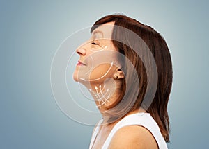 Profile of senior woman with face lifting arrows photo